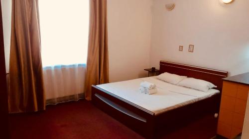 a bedroom with a bed with two towels on it at Heart of Old Town studio with self check in in Bucharest
