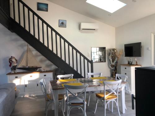 una sala da pranzo con tavolo e sedie di OCEANE a Champagné-les-Marais