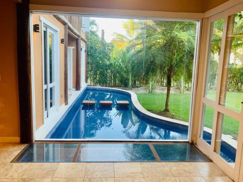 een uitzicht op een zwembad door een glazen schuifdeur bij Suite de Luxo / Frente Mar / Serra Grande, Bahia (Luzimares) in Serra Grande