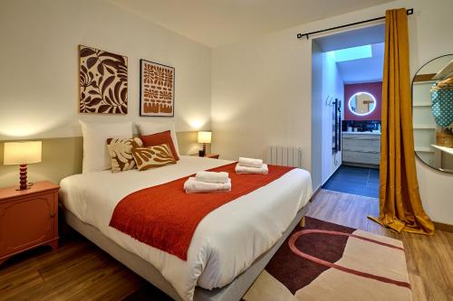 - une chambre avec un grand lit et des serviettes dans l'établissement Le Bouvault, style Appart'Hôtel , à Nevers proche Gare, services haut de gamme by PRIMO C0NCIERGERIE, à Nevers