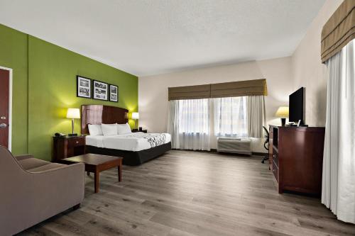 a hotel room with a bed and a tv at Sleep Inn & Suites near Joint Base Andrews-Washington Area in Morningside