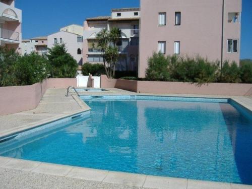 une grande piscine bleue devant un immeuble dans l'établissement Appartement 3 Pièces 5 couchages Plage Richelieu CAP D'AGDE, au Cap d'Agde