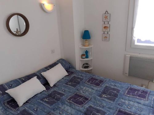 - une chambre avec un lit doté d'une couverture bleue et d'un miroir dans l'établissement Appartement 3 Pièces 5 couchages Plage Richelieu CAP D'AGDE, au Cap d'Agde