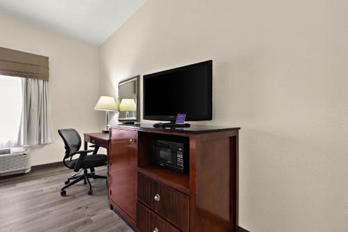 a hotel room with a flat screen tv and a desk at Sleep Inn & Suites near Joint Base Andrews-Washington Area in Morningside