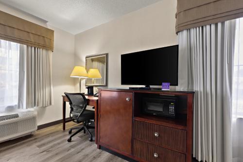 a hotel room with a television and a desk with a chair at Sleep Inn & Suites near Joint Base Andrews-Washington Area in Morningside