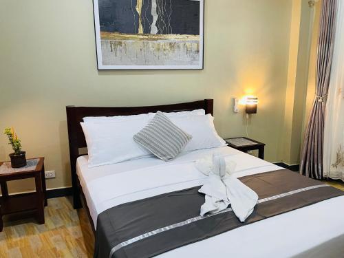 a bedroom with a bed with a bow on it at White Beach Front and Cottages in Buruanga