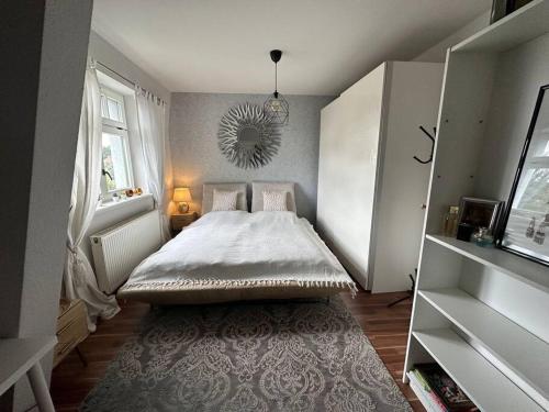 Dormitorio pequeño con cama y espejo en Charmantes Zimmer in Dresden OT Langebrück, en Dresden