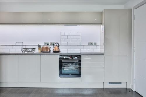 a white kitchen with white cabinets and appliances at Apartments in Sheffield in Sheffield