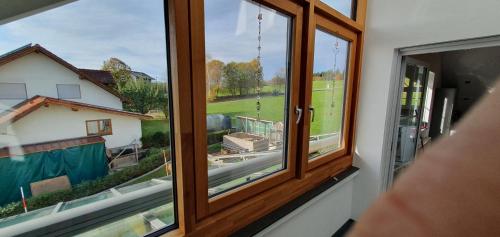 a window with a view of a house at Alpenblick in Leutkirch im Allgäu