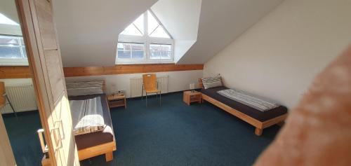 a small room with two beds and a window at Alpenblick in Leutkirch im Allgäu