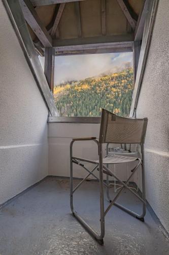 une chaise assise devant une fenêtre dans l'établissement Chamour - A duplex apartment with Mont-Blanc view, à Chamonix-Mont-Blanc