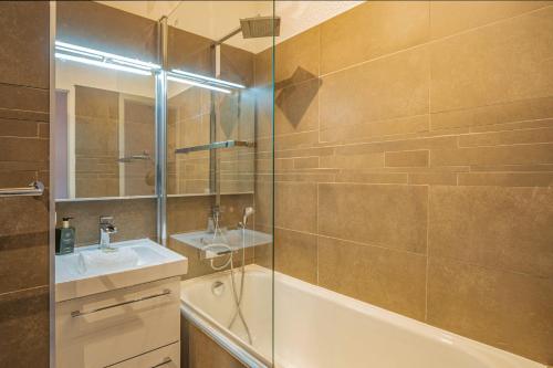 une salle de bain avec une baignoire, un lavabo et une douche dans l'établissement Chamour - A duplex apartment with Mont-Blanc view, à Chamonix-Mont-Blanc