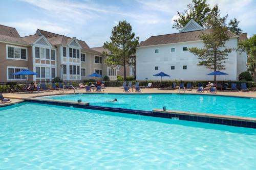 a swimming pool at a resort with people swimming at King's Creek Resort by Spinnaker in Williamsburg