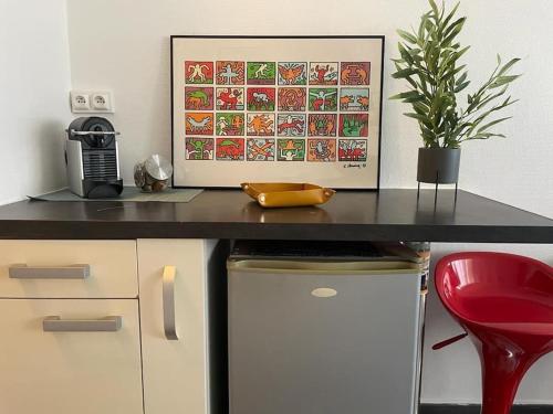 a desk with a picture and a red chair at LE POP ART Studio-Proche tram in Gaillard