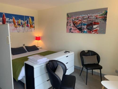 une chambre avec un lit, un bureau et deux chaises dans l'établissement Les 3 Tours et parking, à La Rochelle