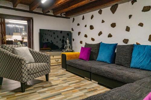 ein Wohnzimmer mit einem Sofa und 2 Stühlen in der Unterkunft Casa Lola in Los Realejos