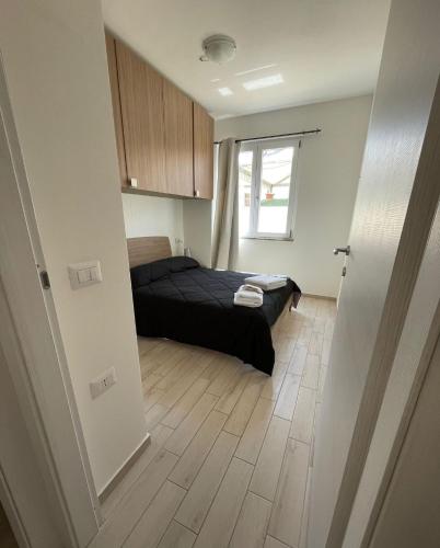 a bedroom with a bed and a wooden floor at Appartamenti Renzo&Rita2 Carmelina in SantʼAntìoco