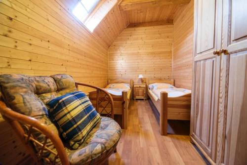Una habitación con 2 camas y una silla en una habitación en Drevenica pod Sitieňom 1, en Lazisko