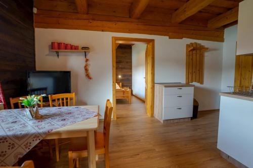 a kitchen and dining room with a table and chairs at Drevenica pod Sitieňom 1 in Lazisko