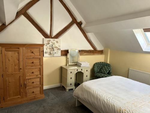 a bedroom with a bed and a tv and a chair at The Byre in Lichfield