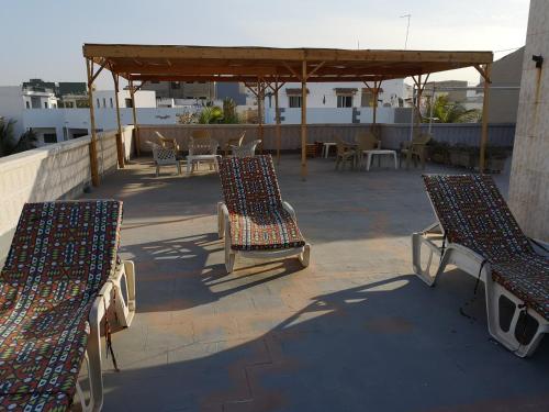 a group of chairs sitting on a patio at Auberge Keur Diame in Dakar