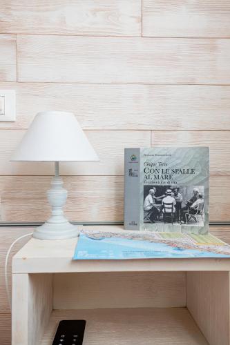 a table with a lamp and a book on it at Alla Marina Affittacamere in Riomaggiore