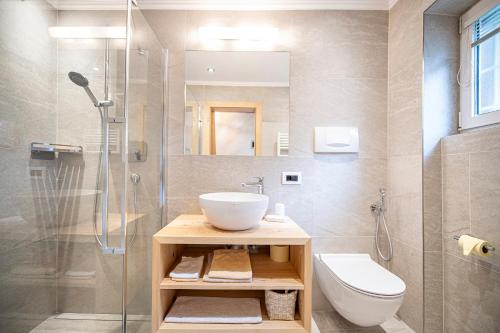 e bagno con lavandino, servizi igienici e doccia. di Appartamenti Olympic a Santa Cristina in Val Gardena