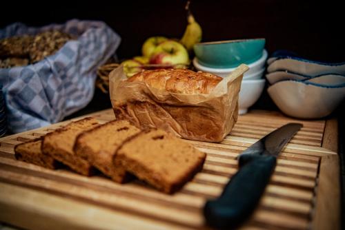 a cutting board with a loaf of bread and a knife at Long John's Pub & Hotel in Amersfoort
