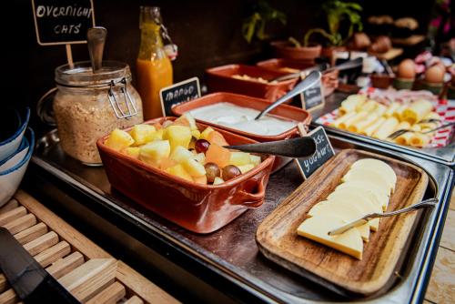 un buffet avec du fromage et d'autres aliments sur une table dans l'établissement Long John's Pub & Hotel, à Amersfoort