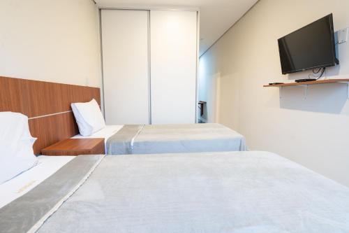 a hotel room with two beds and a flat screen tv at VIVARIUM APART HOTEL in Asuncion