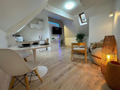 un salon avec une table, des chaises et un canapé dans l'établissement Perle Rare du Centre-ville, à Évreux