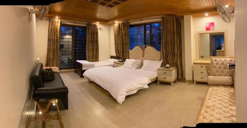 a bedroom with a bed and a chair and a couch at Haven Lodge Bhurban, 6BR Holiday Home in Hill Station in Bhurban