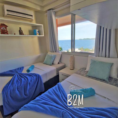 a room with two beds and a view of the ocean at Beto Carrero, vista Espetacular do mar, Home Club in Penha