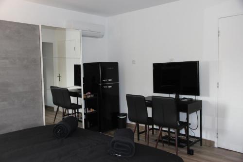 Cette chambre dispose de chaises, d'une télévision et d'un miroir. dans l'établissement Maison d'hote villa monique, à Cuges-les-Pins