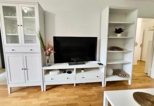 a white entertainment center with a flat screen tv at Appartement lumineux in Saint-Denis