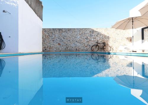 uma vista para uma piscina com um guarda-sol e uma bicicleta em MyStay - Casa de Baco em Igrejinha