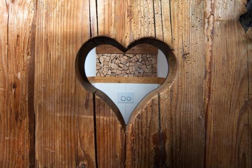 a heart shaped hole in a wooden door at Ettlerlehen Chalets in Ramsau