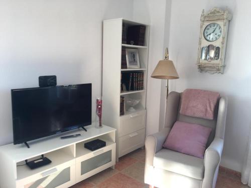 - un salon avec une télévision à écran plat et une chaise dans l'établissement El Mirador de Sierra Mágina, 