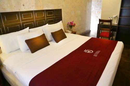 sypialnia z dużym łóżkiem z czerwonym i białym kocem w obiekcie Hoteles Riviera Colonial w mieście Arequipa