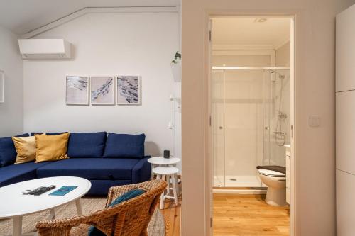 a living room with a blue couch and a table at Akicity Anjos Splendid in Lisbon