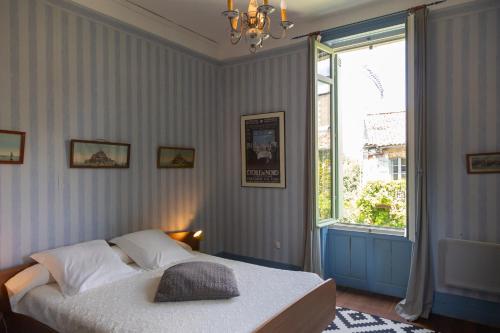 a bedroom with a bed and a large window at Le Domaine du Meunier in Mortagne-sur-Gironde
