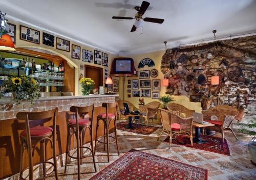 a bar with a bunch of stools in a room at Hotel Garnì Riviera in Gargnano