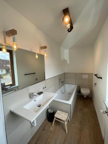 a bathroom with a sink and a tub and a toilet at Haus Renate in Timmendorfer Strand