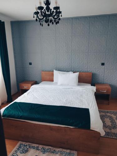 a bedroom with a large bed and a chandelier at Cabana Good Vibes in Cluj-Napoca