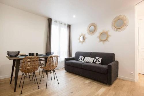 un salon avec un canapé, une table et des chaises dans l'établissement Amazing 6 pax place near Opera, à Paris