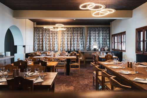 une salle à manger avec des tables et des chaises en bois dans l'établissement Le Refuge du Grand Hôtel - Altitude 1900 m, à Saint-Chaffrey