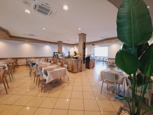 a restaurant with tables and chairs and a bar at Hotel Butterfly in Rimini