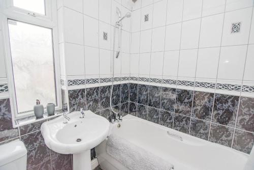 uma casa de banho com um lavatório, uma banheira e um WC. em K Suites - Arthur Street Doncaster em Bentley