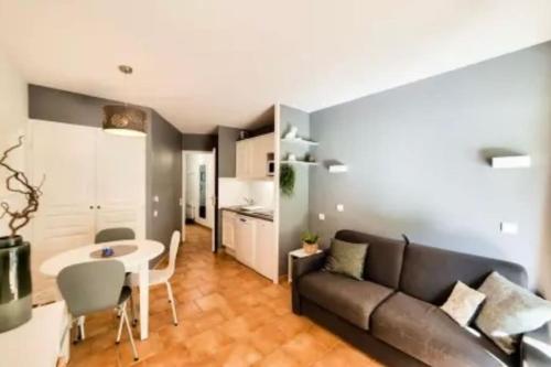 un salon avec un canapé et une table dans l'établissement Appartement 2 pièces, Rez de jardin et terrasse, à Deauville
