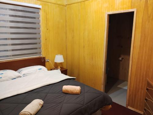 um quarto com uma cama grande e uma janela em Residencial 4 estaciones em Futaleufú